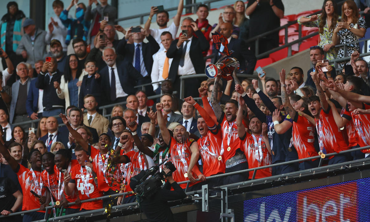 Luton Town’s Sonny Bradley lifts the trophy with teammates after winning their Championship Play-Off Final against Coventry City at Wembley Stadium, London on May 27, 2023. (Reuters)