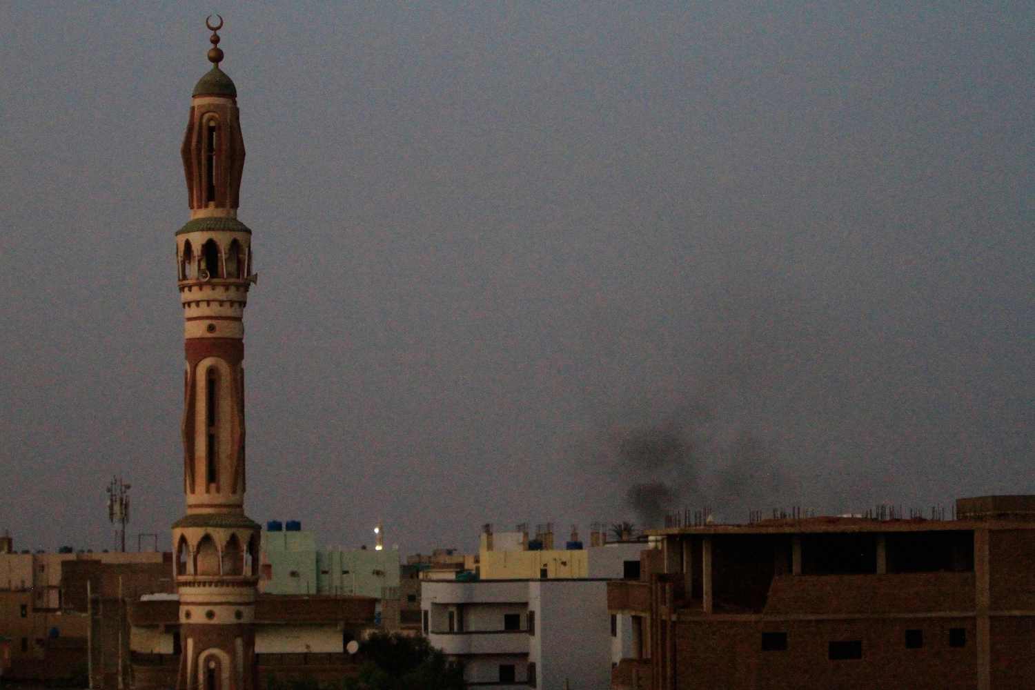 Smoke billows behind buildings in southern Khartoum, on May 27, 2023, amid ongoing fighting between the forces of two rival generals. (AFP)
