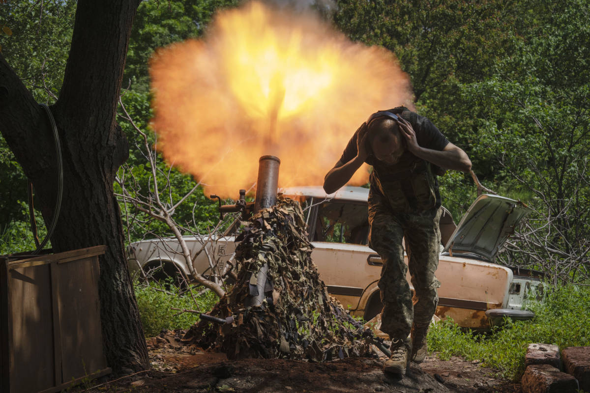 A Ukrainian soldier covers his ears while firing a mortar at Russian positions on the frontline near Bakhmut, Donetsk region, Ukraine, Monday, May 29, 2023. (AP)