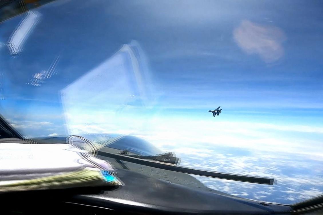 A J-16 fighter pilot from China flies in front of the nose of a US Air Force RC-135 aircraft over the South China Sea in this screengrab made from video taken on May 26, 2023. (DVIDS handout/AFP)