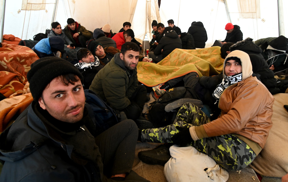 Above, migrants in transit, mostly from Afghanistan, rest in a tent near the railway station in Rijeka on the Adriatic coast in western Croatia on Feb. 6, 2023. (AFP)