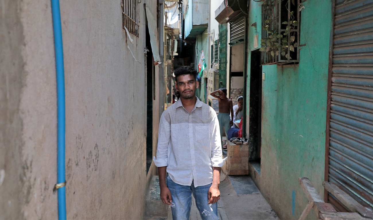 Nizamudin Abdul Rahim Khan, 23, a worker, poses for a photograph in an alley at a slum area in Mumbai, India, on May 20, 2023. (REUTERS)