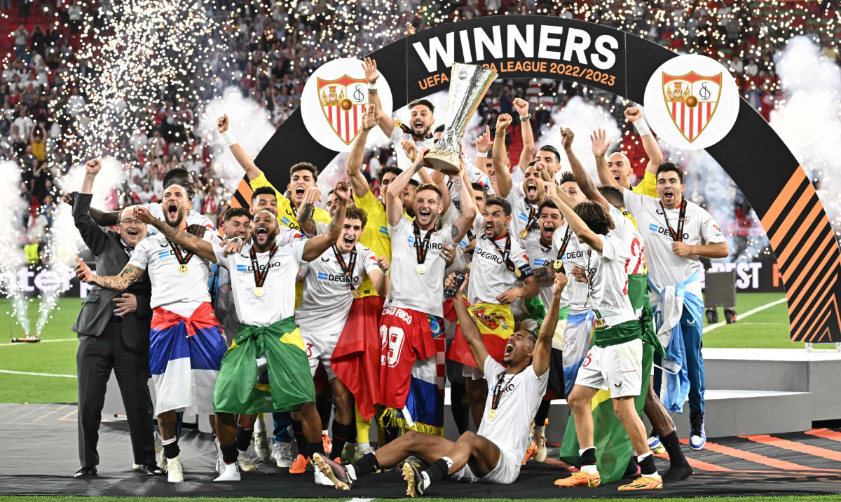 Sevilla players celebrate with the trophy after winning the UEFA Europa League final football match between Sevilla FC and AS Roma at the Puskas Arena in Budapest on Wednesday. (AFP)