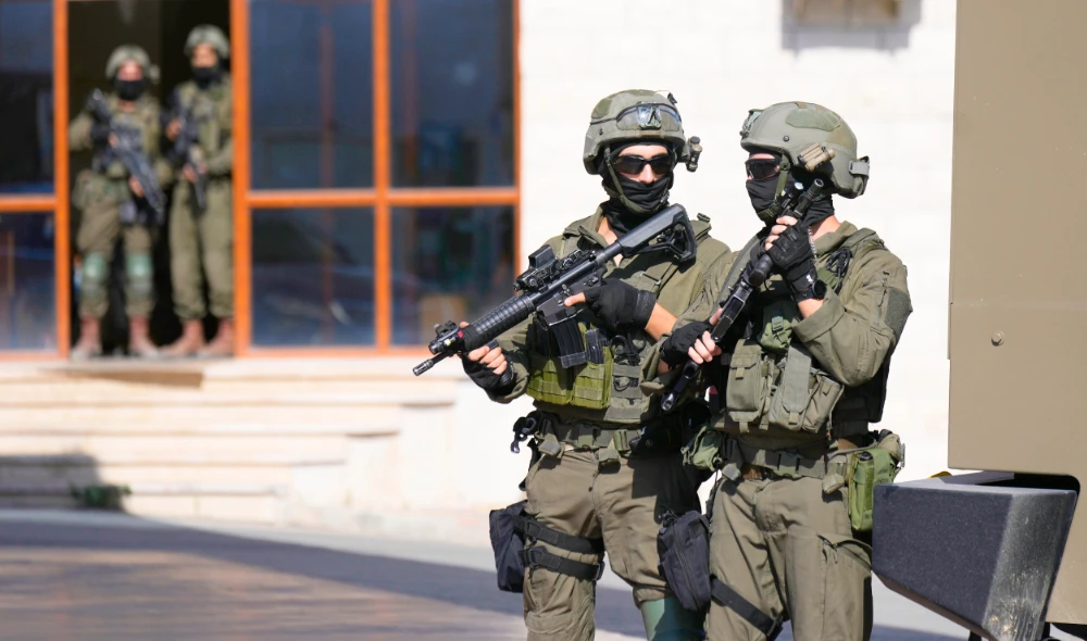 Israeli soldiers search in the West Bank village of Qafin for the suspected gunmen. (AP)