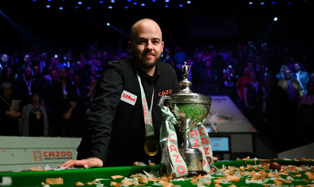 Belgium’s Luca Brecel celebrates with the trophy after winning against England’s Mark Selby in the Snooker World Championship final match at The Crucible in Sheffield, northern England on Monday. (AFP)