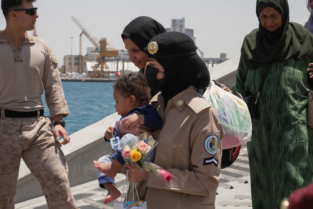 A Saudi Royal Navy female officer helps a woman disembark from a ship at the Jeddah Sea Port, Jeddah, Saudi Arabia, May 1, 2023. (Reuters)