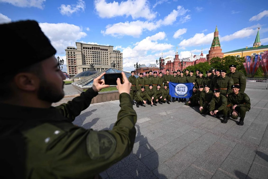 Cossacks pose for a group photo on Manezhnaya square just off the Kremlin in downtown Moscow on May 3, 2023. (AFP)