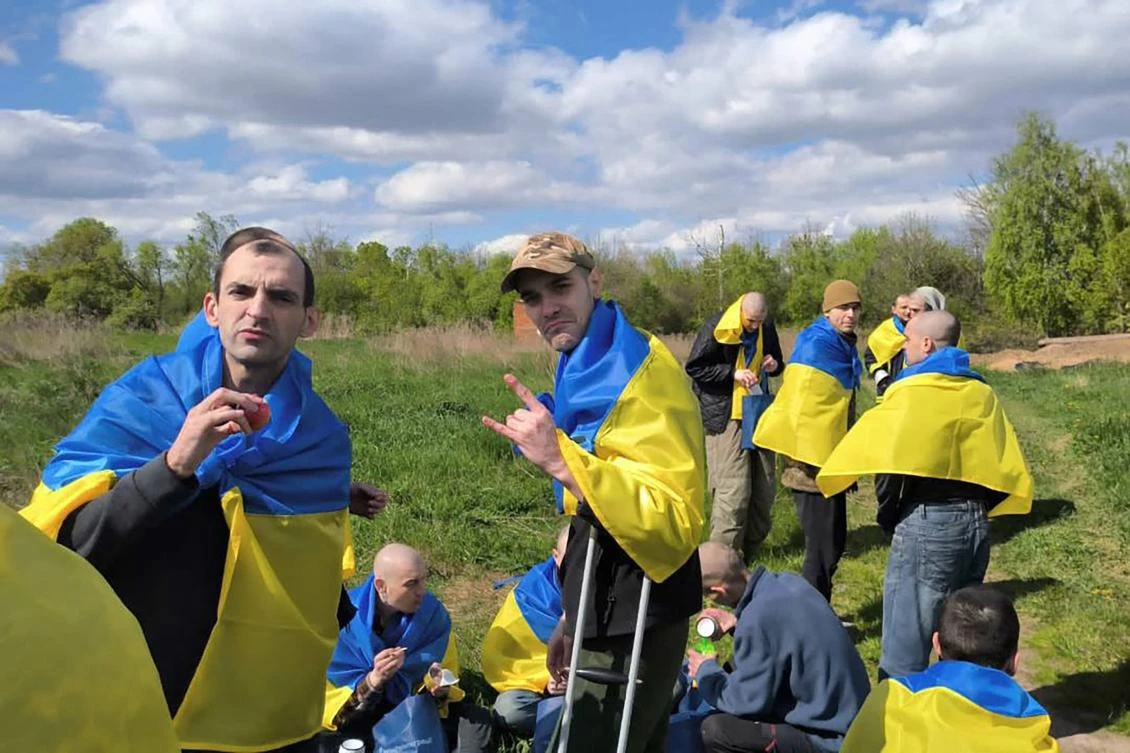 This handout photograph taken and released by Ukrainian Presidential Chief of Staff Andriy Yermak on May 6, 2023, allegedly shows freed Ukrainian prisoners reacting following their exchange in an unknown location in Ukraine. (AFP)