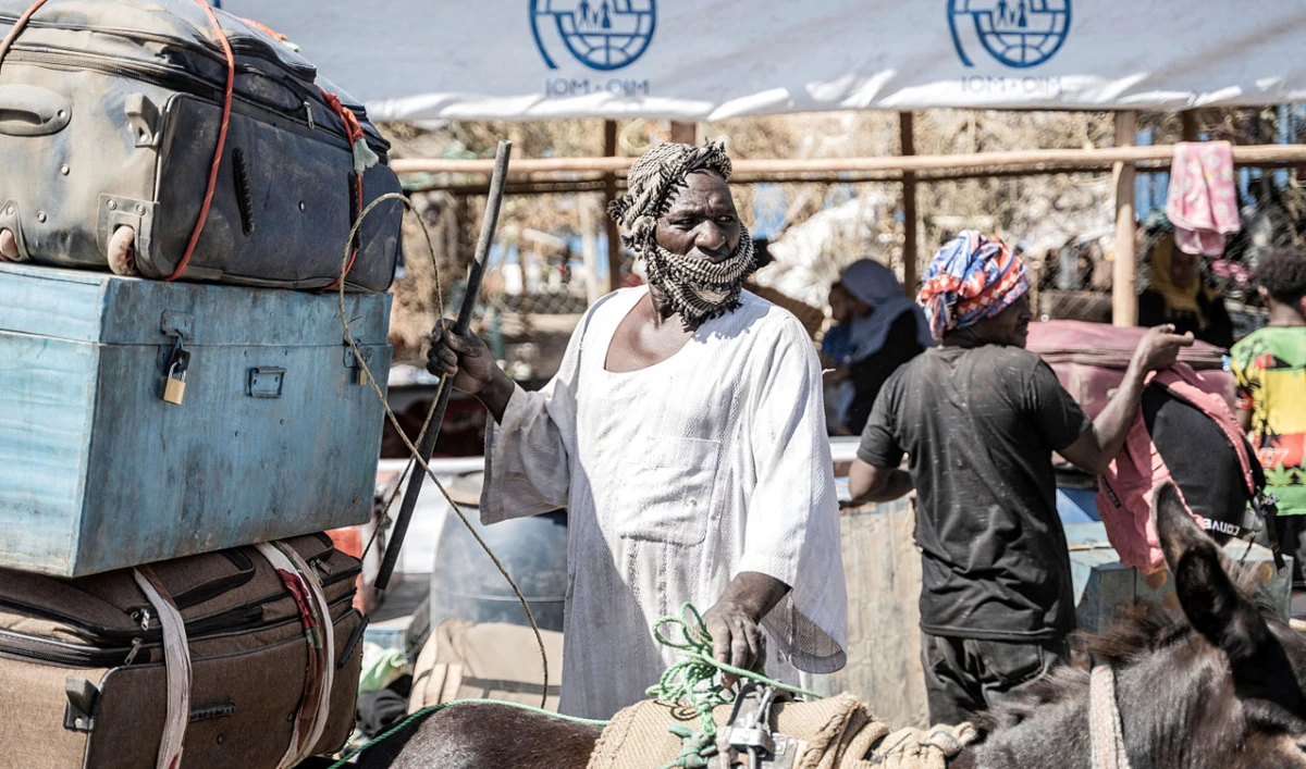 A man offloads belongings of refugees from Sudan in Metema, Ethiopia. More than 15,000 people have fled Sudan via Metema since fighting broke out in Khartoum in mid-April, with around a thousand arrivals registered per day on average. (AP)