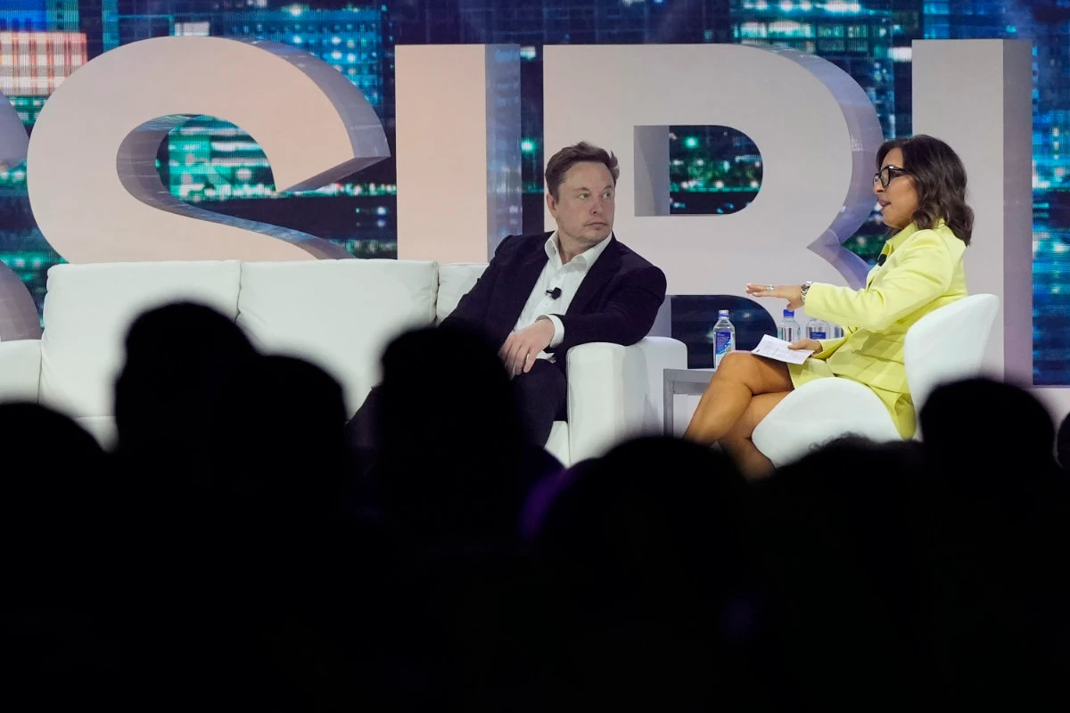 Twitter CEO Elon Musk, center, speaks with Linda Yaccarino, chairman of global advertising and partnerships for NBC, at the POSSIBLE marketing conference, on April 18, 2023, in Miami Beach, Florida. (AP)