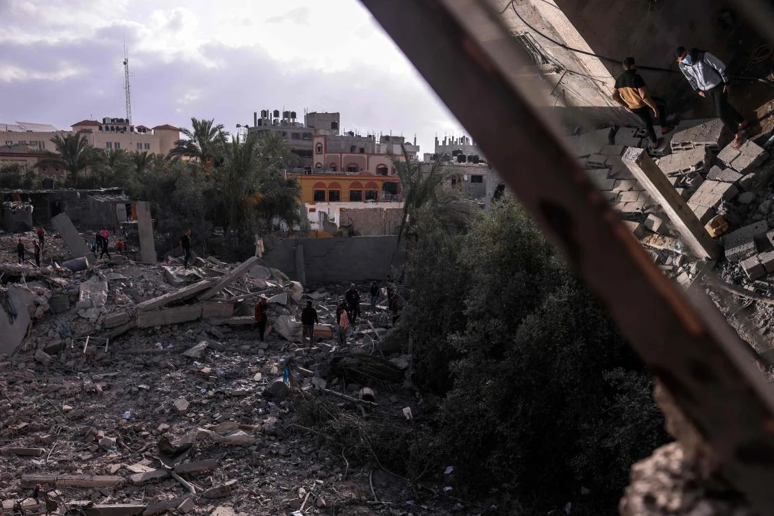People sift through the rubble of a building hit by an Israeli air strike in Deir al-Balah in the centre of the Gaza Strip. (AFP)