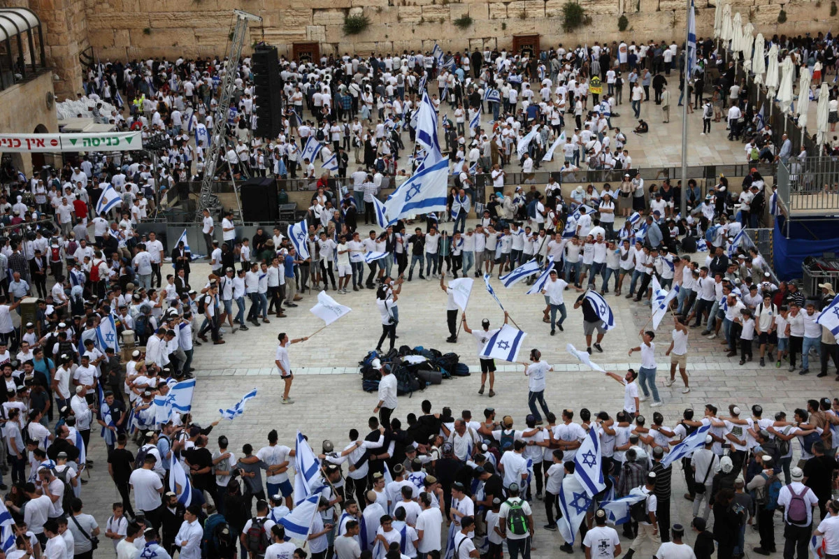 Israelis wave national flags as they gather at the Western Wall in the Old City of Jerusalem during the Israeli 'flags march' to mark "Jerusalem Day", on May 18, 2023. (AFP)