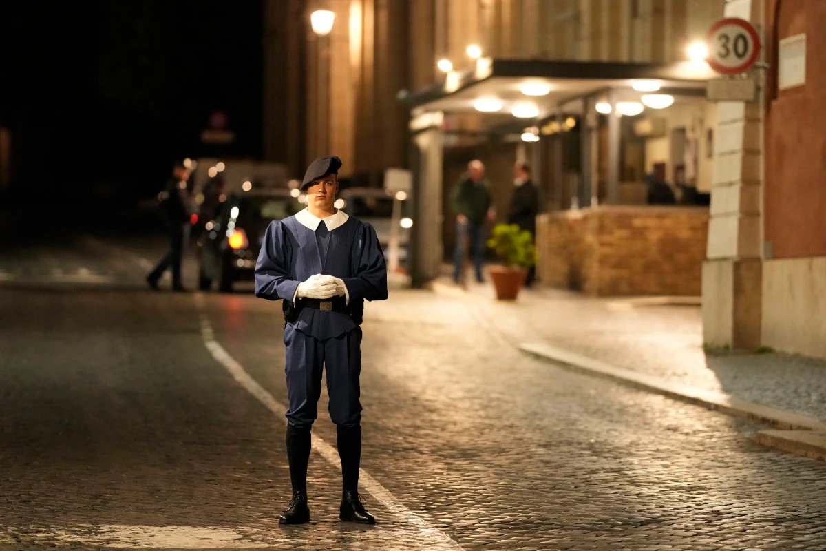 A Swiss Guard officer patrols the Santa Anna gate at the Vatican late Thursday. (AP)