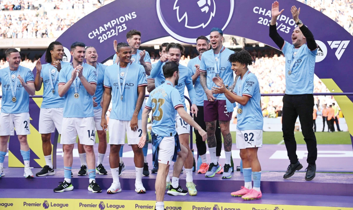 Manchester City’s Spanish manager Pep Guardiola, right, and his players gather on the podium at the Premier League presentation ceremony following the English Premier League football match between Manchester City and Chelsea at the Etihad Stadium in Manchester, northwest England, on Sunday. (AFP)