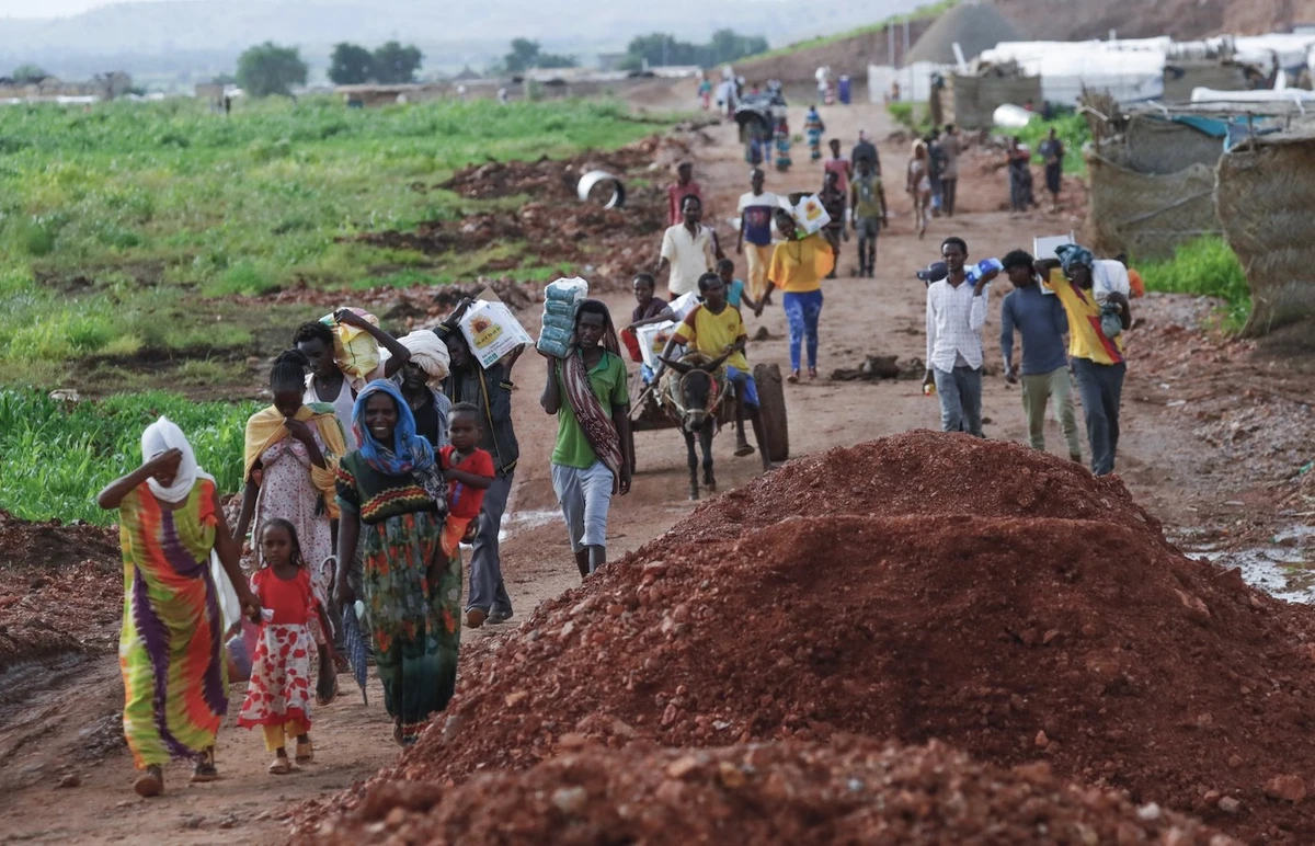 Ethiopian refugees who fled the fighting in the Tigray region transport jerrycans of water at Umm Rakuba camp in eastern Sudan’s Gedaref State. (File/AFP)