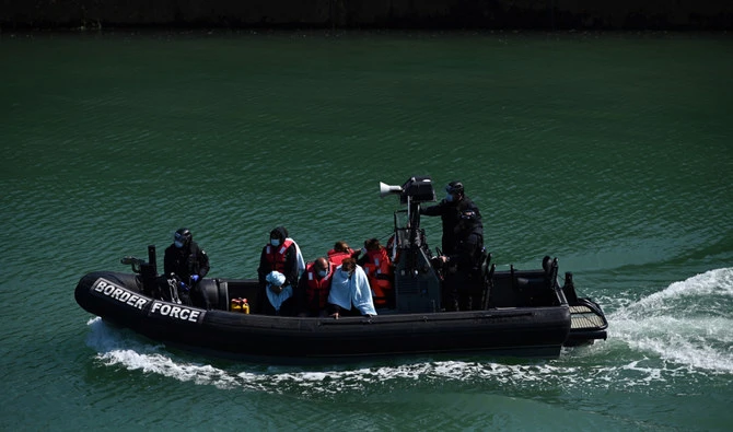 Migrants are seen on the UK Border Force rubber dinghy, after they were picked up at sea while attempting to cross the English Channel, and brought to the Marina in Dover, southeast England, on June 16, 2022. (AFP/File)