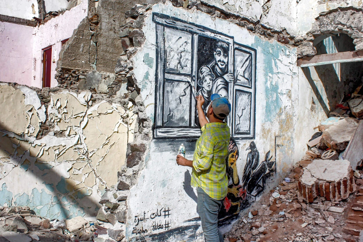Yemeni street artist Alaa Rubil finishes one of his artworks painted on a wall in the southern port city of Aden. (Saleh Al-Obeidi / AFP)