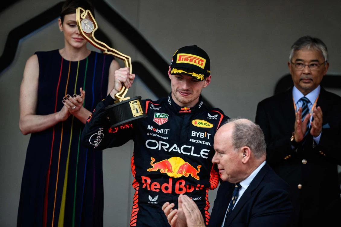 Red Bull Racing's Dutch driver Max Verstappen (C) poses with his trophy on the podium flanked by Prince Albert II of Monaco (R) and Princess Charlene of Monaco (L) after winning the Formula One Monaco Grand Prix at the Monaco street circuit in Monaco, on May 28, 2023. (AFP)