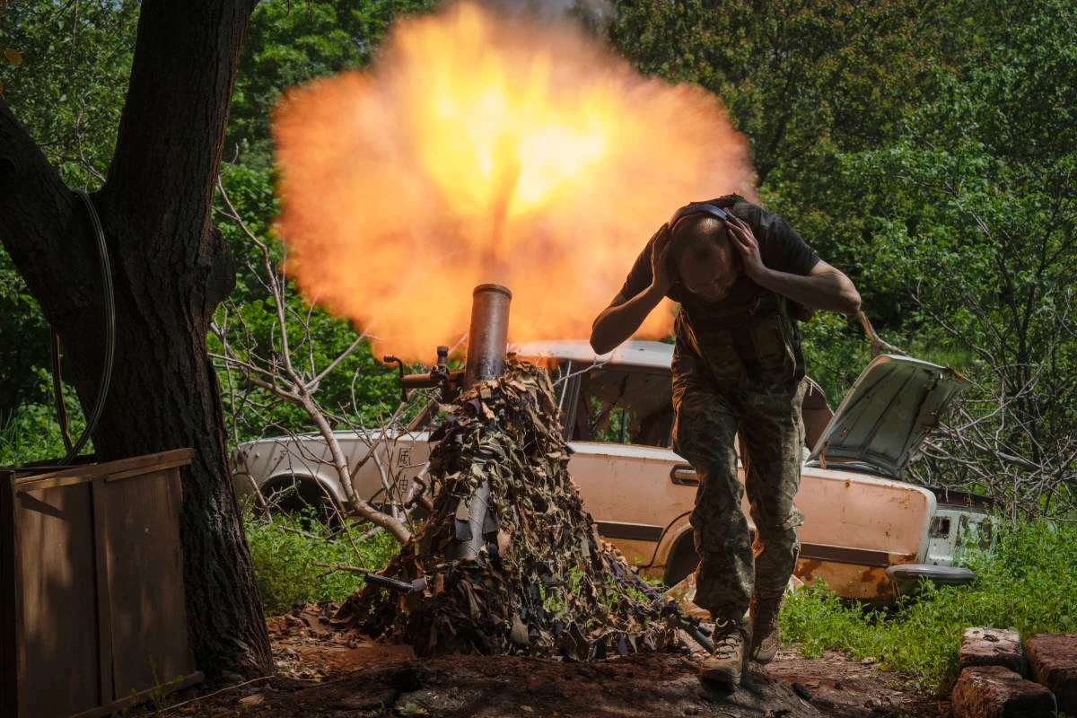 A Ukrainian soldier covers his ears while firing a mortar at Russian positions on the frontline near Bakhmut, Donetsk region, Ukraine, Monday, May 29, 2023. (AP)