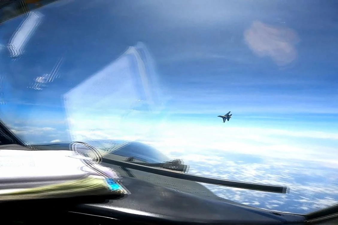 A J-16 fighter pilot from China flies in front of the nose of a US Air Force RC-135 aircraft over the South China Sea in this screengrab made from video taken on May 26, 2023. (DVIDS handout/AFP)