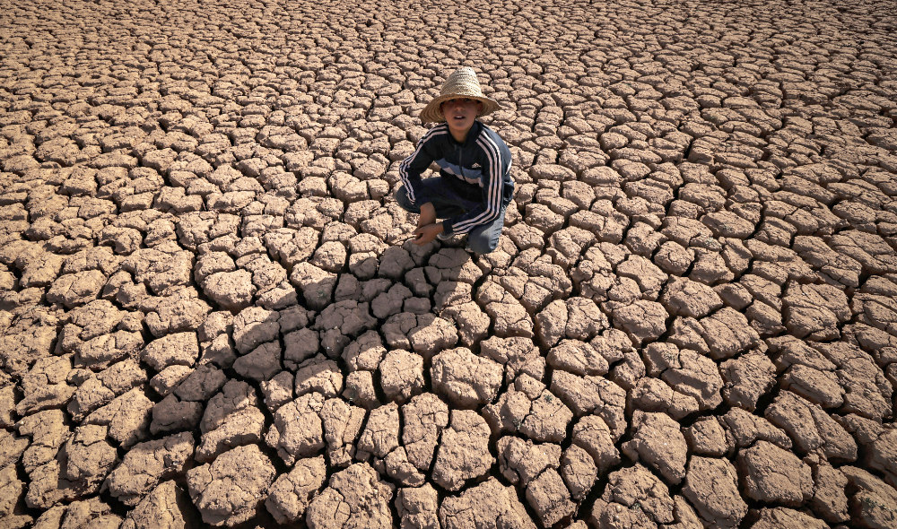 A child crouches over cracked earth at al-Massira dam in Ouled Essi Masseoud village, some 140 kilometres (85 miles) south from Morocco's economic capital Casablanca. (AFP)