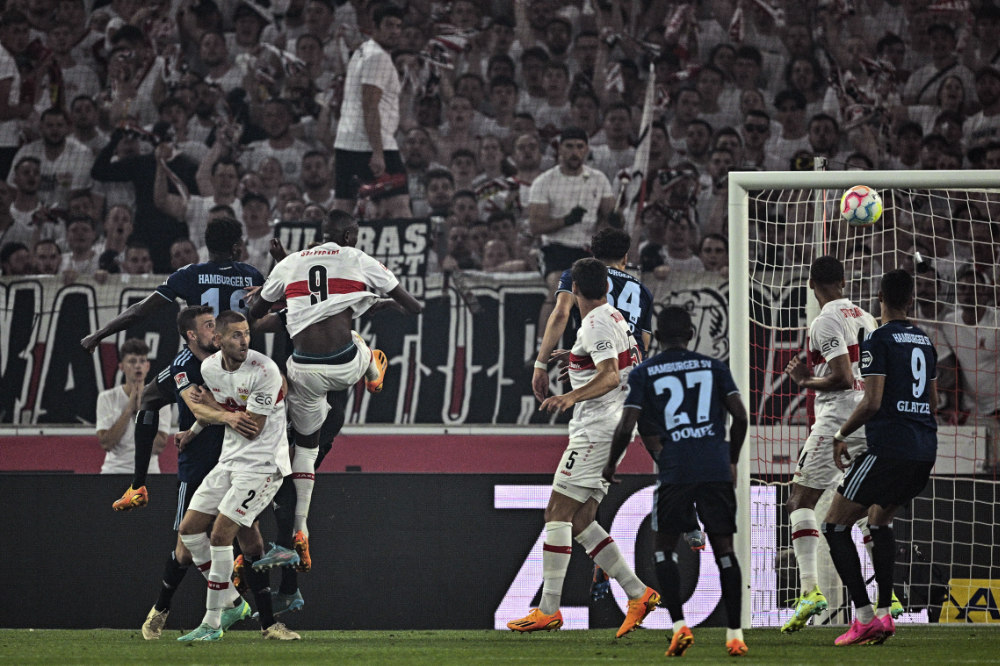 Stuttgart's Serhou Guirassy, center left, scores his side's third goal of the game during the first leg of their German Bundesliga relegation soccer match against Hambur at the Mercedes-Benz Arena in Stuttgart Thursday. (dpa via AP)
