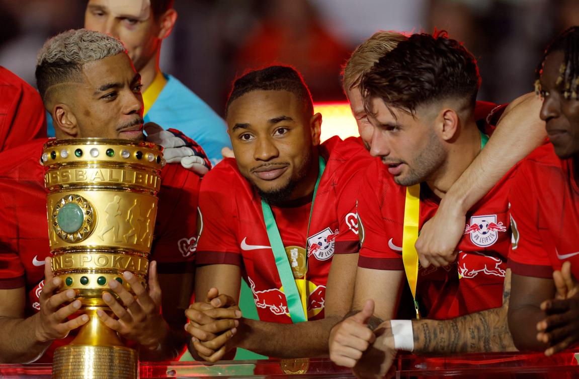 Leipzig’s German defender Benjamin Henrichs, French forward Christopher Nkunku and Hungarian midfielder Dominik Szoboszlai celebrate with the trophy after their team won the German Cup (DFB Pokal) final match against Eintracht Frankfurt in Berlin on Jun. 3, 2023. (AFP)