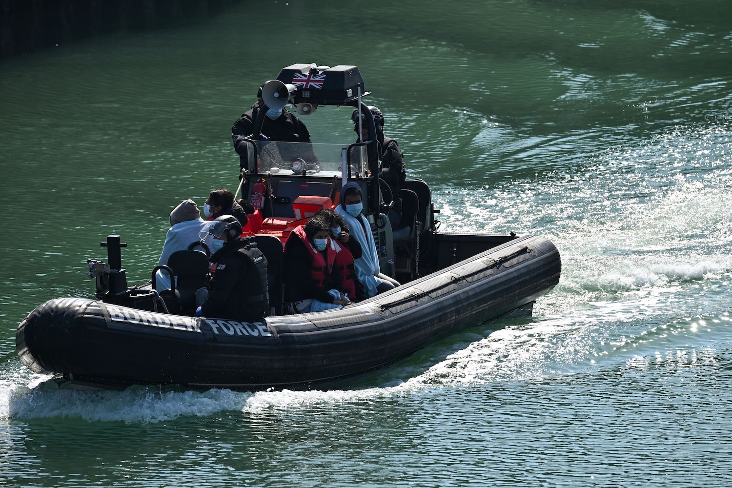 Migrants are seen on the UK Border Force rubber dinghy, after they were picked up at sea while attempting to cross the English Channel. (File/AFP)