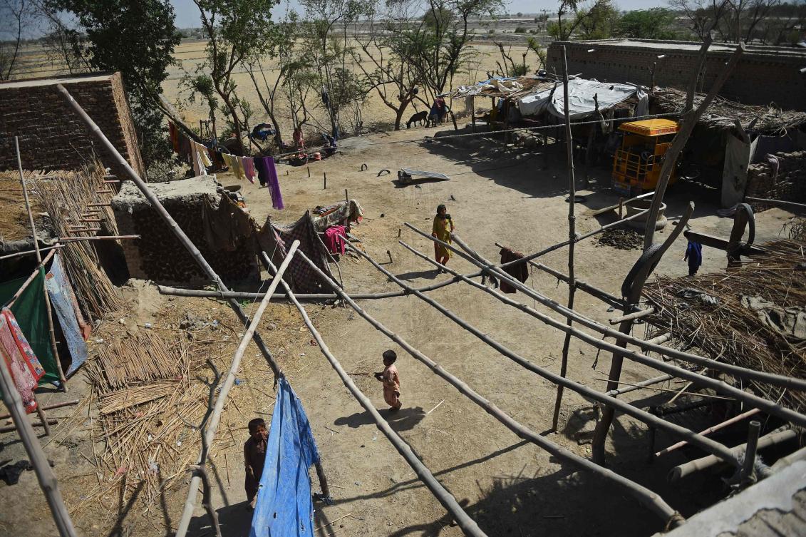 In this photograph taken on May 9, 2023, flood-affected victims walk through the compound of their damaged house in Dadu district of Pakistan.(AFP)
