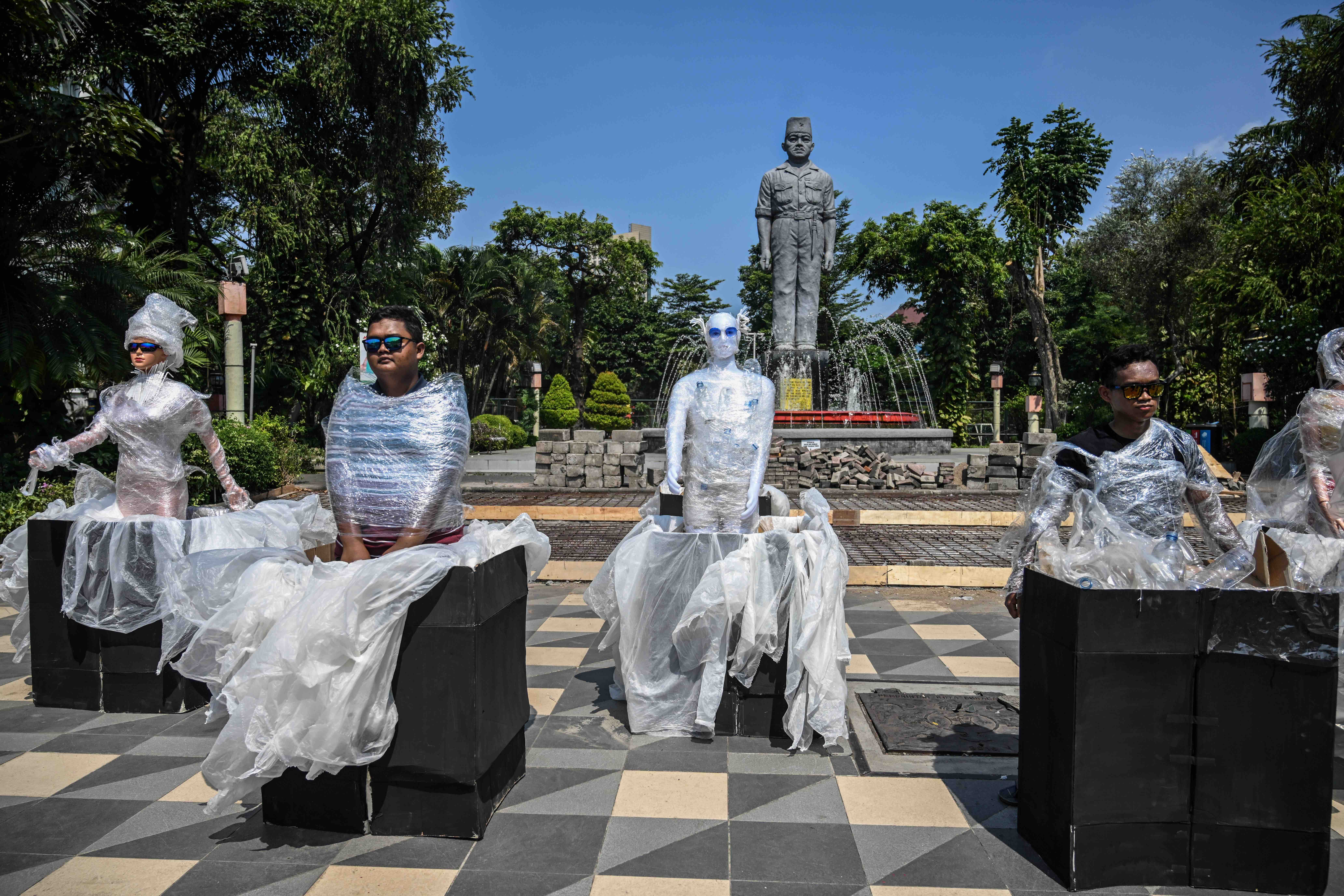 Environmental activists wearing plastic next to mannequins dressed in plastic waste take part in a campaign against climate change to mark the World Environment Day in Surabaya. (AFP)
