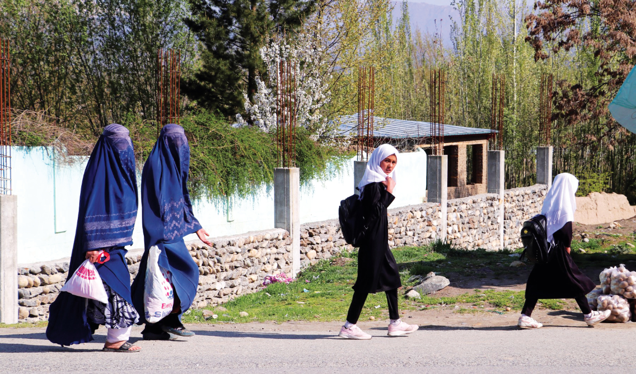 Afghan women along with school girls walk along a road in Fayzabad district of Badakhshan province on March 26. (File/AFP)