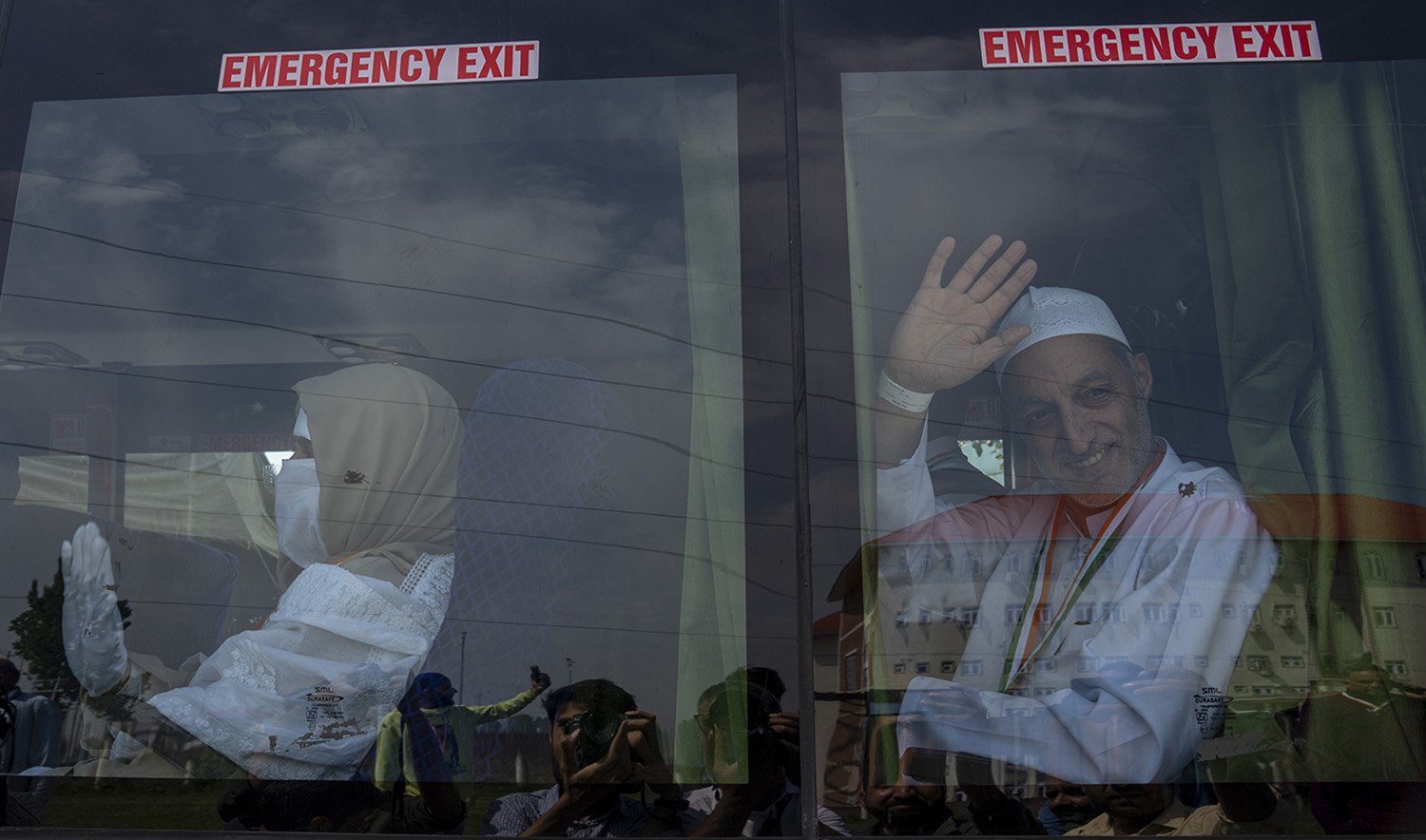 Kashmiri Muslim pilgrims wave from a bus as they depart for Saudi Arabia to perform the annual hajj pilgrimage, in Srinagar on June 7, 2022. (AP)