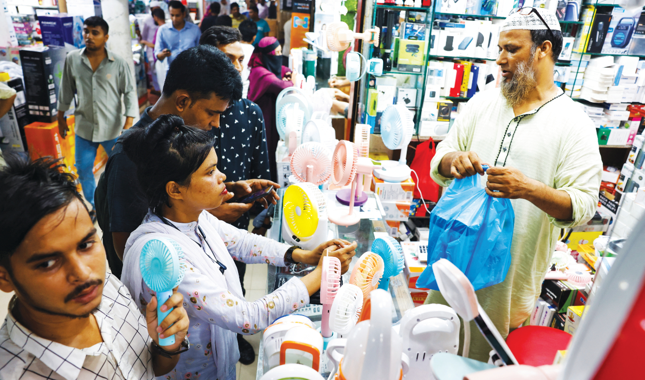 People gather at an electronics shop to purchase charger fans during a countrywide heat wave in Dhaka, Bangladesh, on Tuesday. (Reuters)
