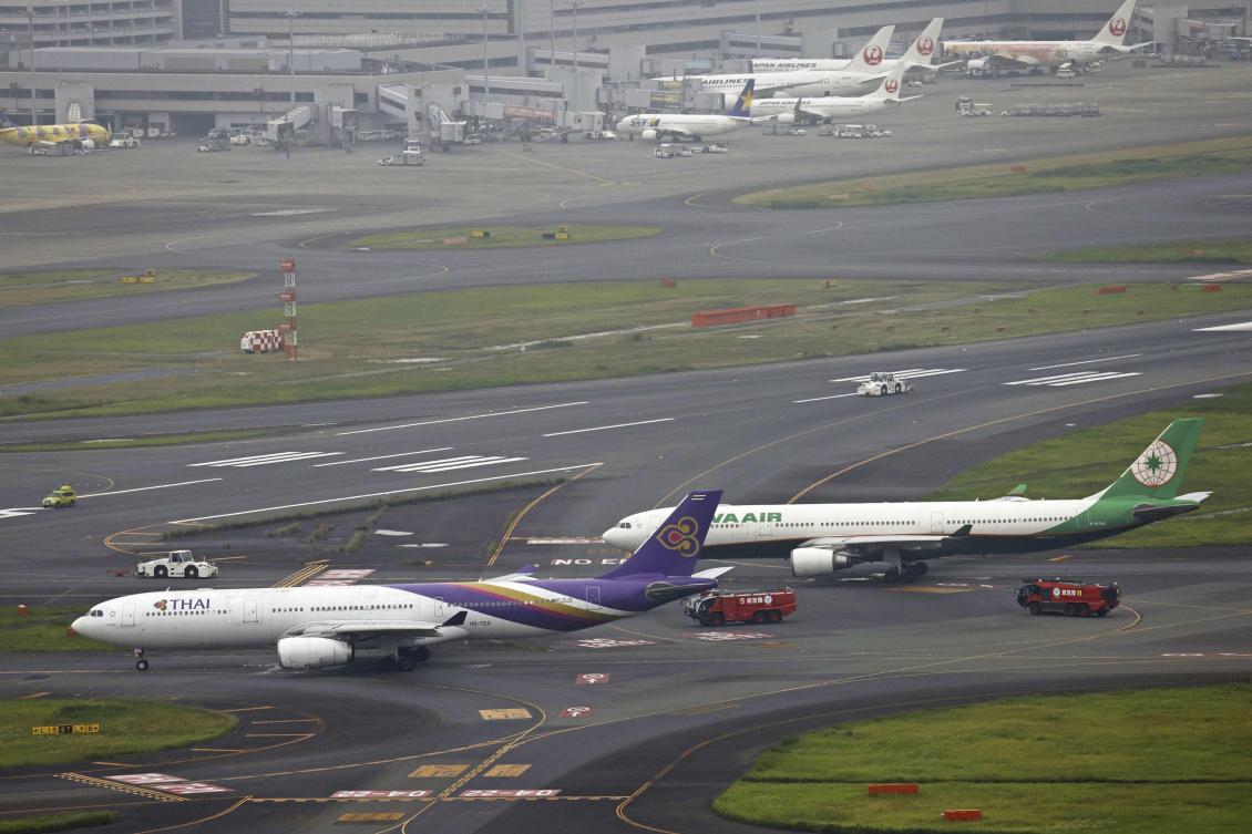Thai Airways International, left, and Eva Airways, right, sit close on a runway, after the two passenger planes accidentally hit each other at Haneda airport in Tokyo on June 10, 2023. (Kyodo News via AP)