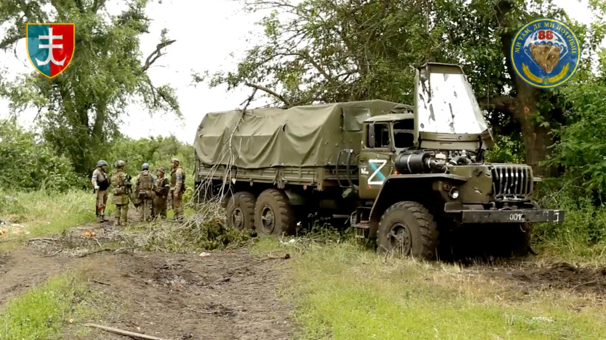 Ukrainian servicemen of the 35th Separate Brigade of Marines stand near a destroyed military vehicle in the liberated village of Storozheve, in Dontesk region in the still image taken from a social media video released on June 12, 2023. (Reuters)
