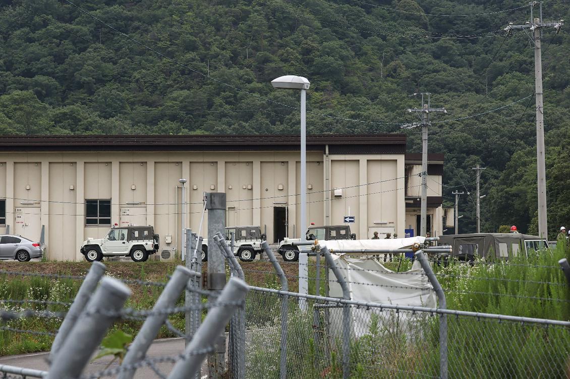 Vehicles and members of Japan's Ground Self-Defense Force (SDF) pictured outside a building at the Hino basic firing range in Gifu, where the shooting incident occurred. (AFP)