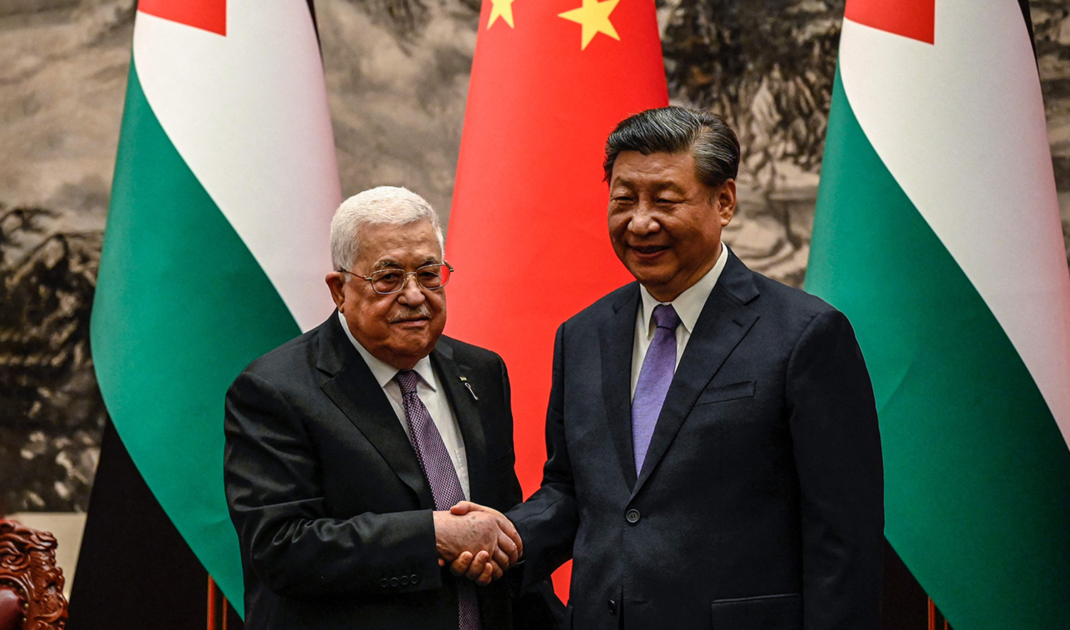 China's President Xi Jinping, right, shakes hands with Palestinian President Mahmud Abbas during a welcoming ceremony at the Great Hall of the People in Beijing on June 14, 2023. (AFP)