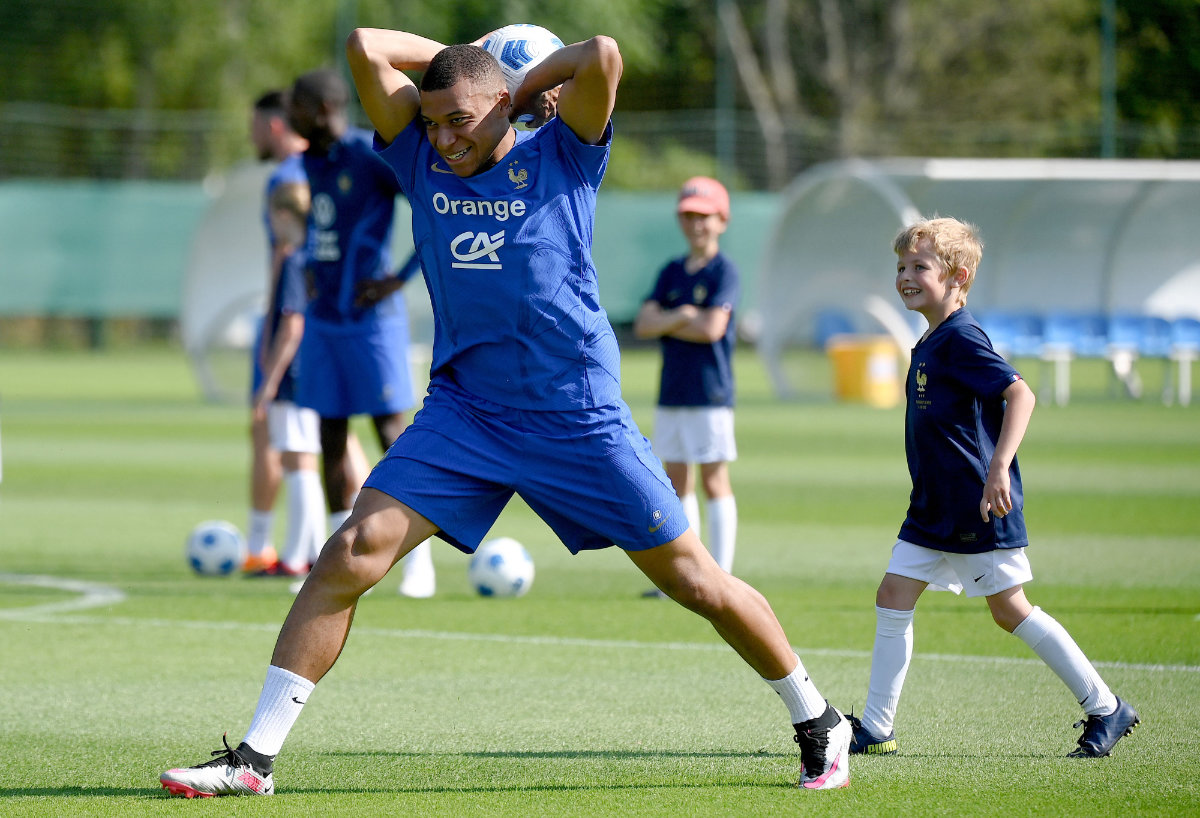 France's forward Kylian Mbappe demonstrates a throw in to a young fan during a training session in Clairefontaine-en-Yvelines on Wednesday, as part of the French national team's preparations for the upcoming UEFA Euro 2024 qualifying matches. (AFP)