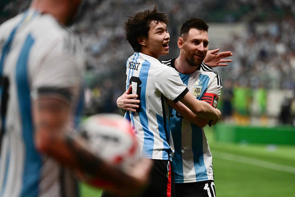 A fan embraces Argentina’s Lionel Messi during a friendly football match between Australia and Argentina at the Workers’ Stadium in Beijing on June 15, 2023. (AFP)