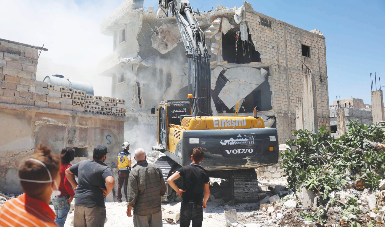 A White Helmets Civil Defense excavator demolishes a building — damaged in the Feb. 6 earthquake — in the western countryside of Syria’s Aleppo province. (AFP)