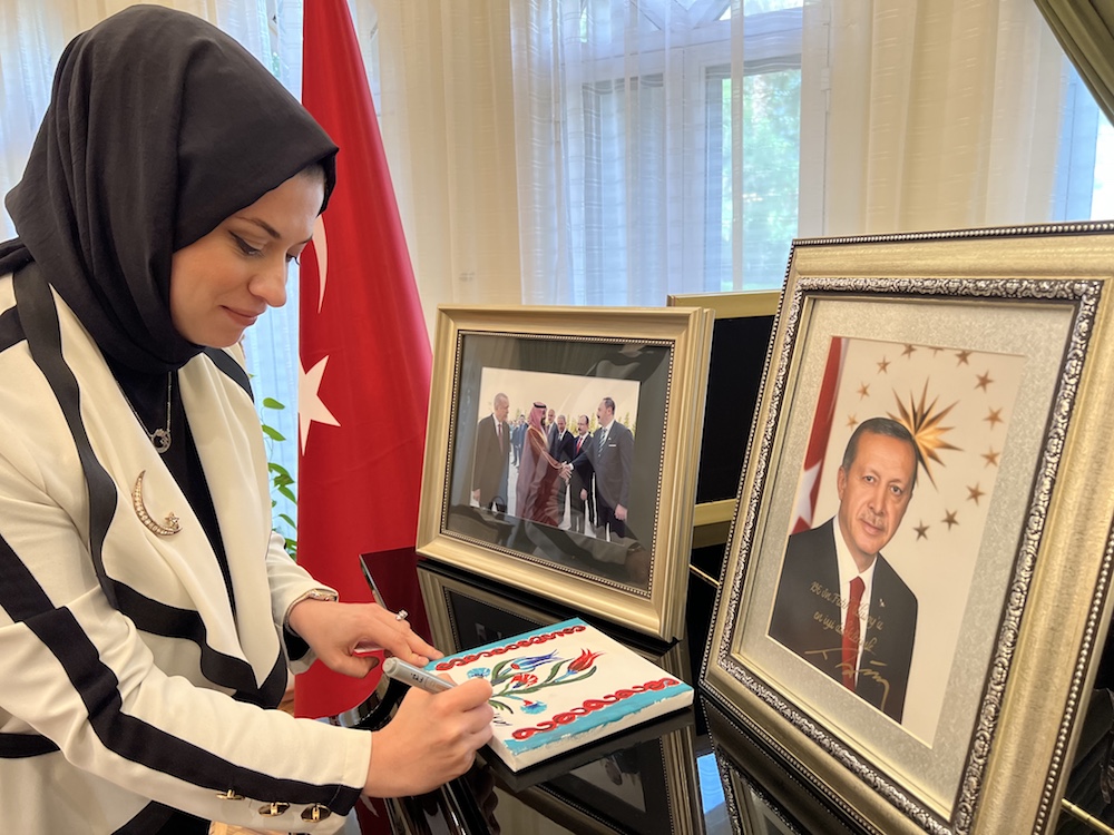 Seyma Nur Ulusoy singing her name on her painting. (AN Photo/Lama Alhamawi)