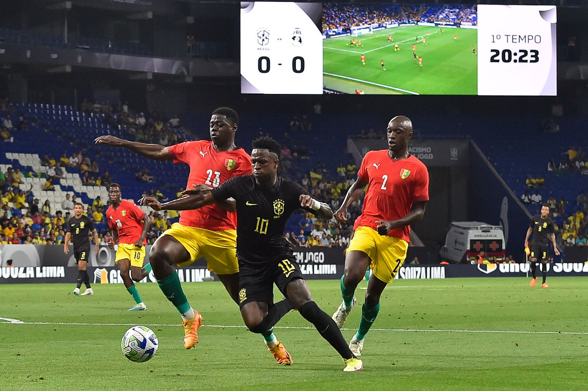 Brazil's forward Vinicius Junior (C) fights for the ball with Guinea's defenders Saidou Sow (L) and Antoine Conte during the international friendly football match between Brazil and Guinea at the RCDE Stadium in Cornella de Llobregat near Barcelona on Saturday. (AFP)