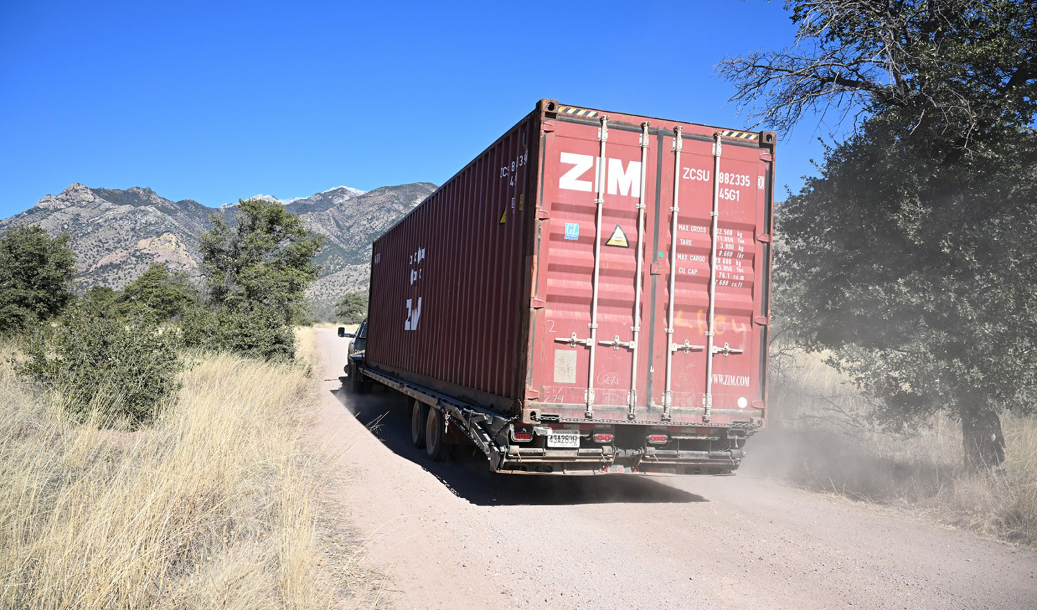This representational photo shows a shipping container being removed from a long row of those stacked to create a wall between the United States and Mexico in the Coronado National Forest near Hereford, Arizona, on January 20, 2023. (AFP/File)