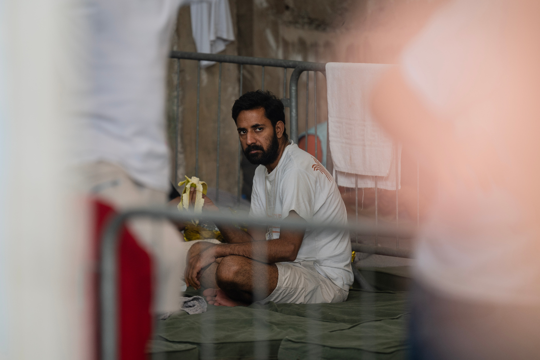 Survivor of a shipwreck sits inside warehouse at the port in Kalamata town, after a boat carrying migrants sank in international waters in the Ionian Sea. (File/AFP)