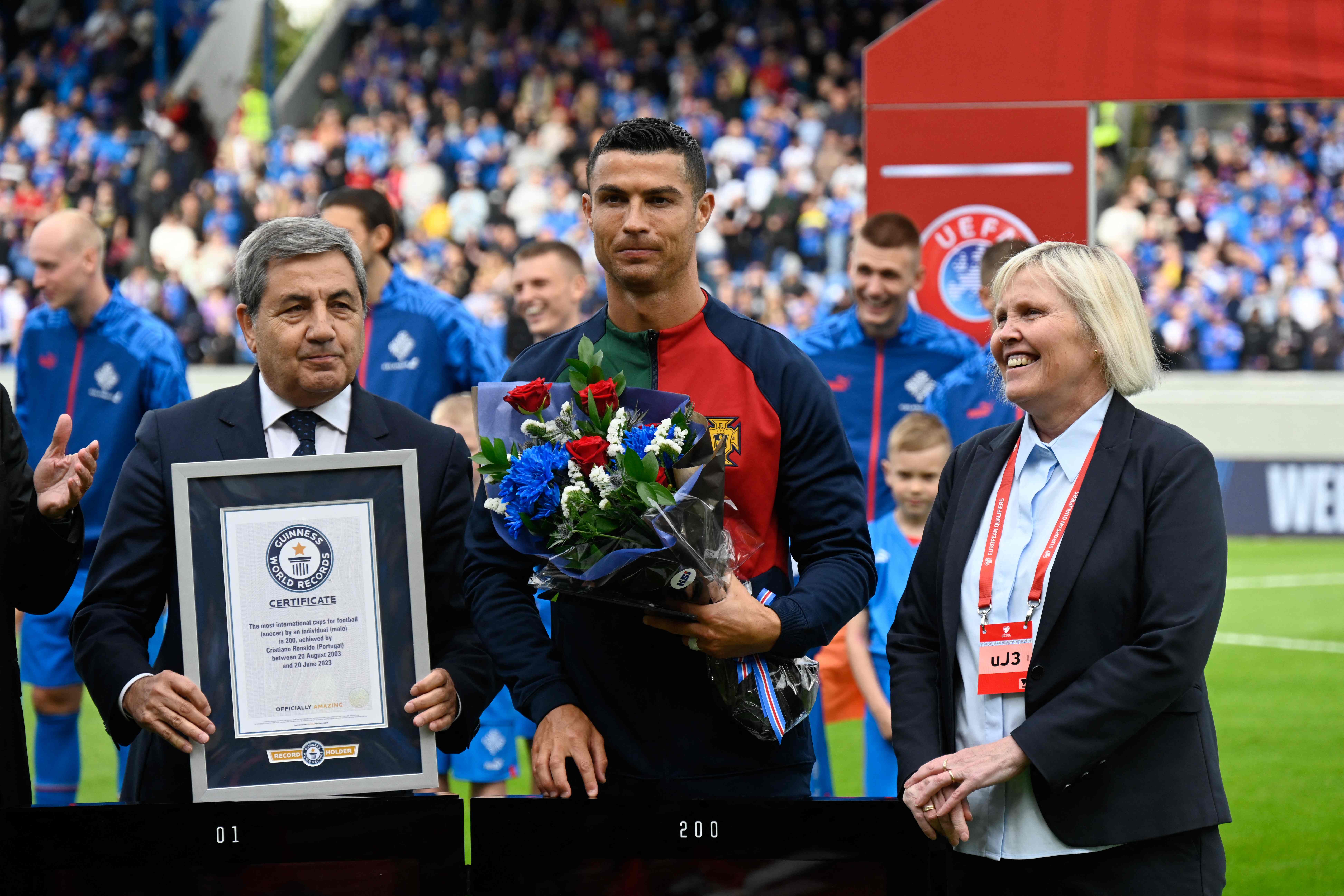 Portugal's forward Cristiano Ronaldo (C) is honored with a certificate of the Guinness World Records for having reached 200 games for Portugal prior to the UEFA Euro 2024 group J qualification match against Iceland in Reykjavik. (AFP)