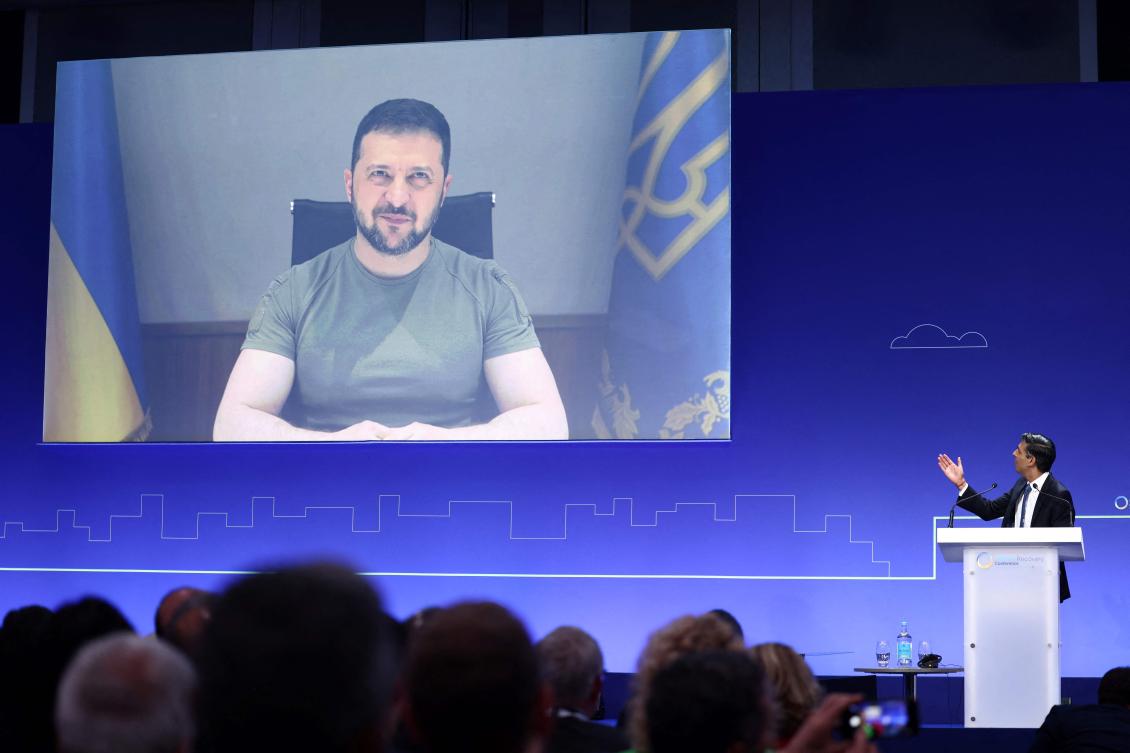 Britain’s Prime Minister Rishi Sunak introduces Ukraine’s President Volodymyr Zelensky as he appears on the screen on the first day of the Ukraine Recovery Conference in London on June 21, 2023. (AFP)
