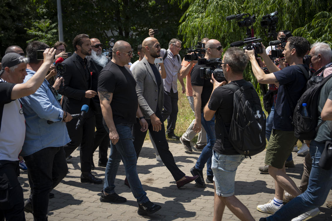 Andrew Tate walks with bodyguards as he leaves the Bucharest Tribunal, along with his brother Tristan, after the first hearing in their trial, meant to establish if they will remain under house arrest, in Bucharest, on June 21, 2023. (AP)