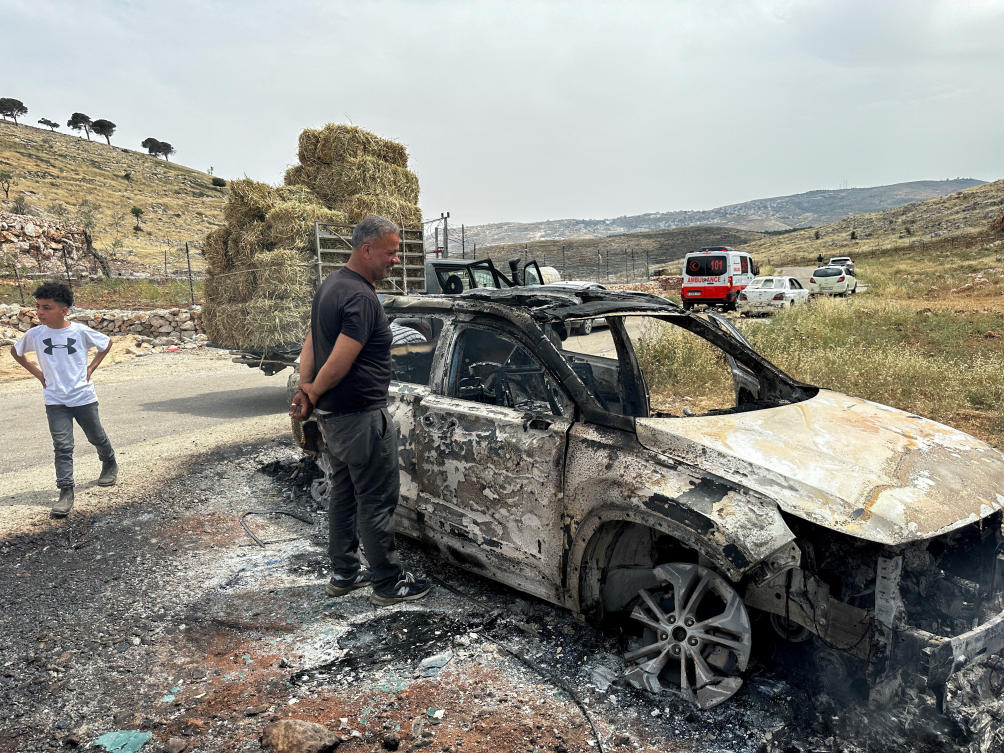 Palestinians check a car burned by Israeli settlers during clashes near Ramallah in the Israeli-occupied West Bank last May 2023. (REUTERS/File)