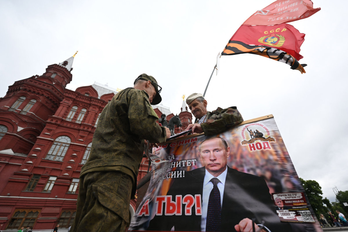 Activists hold a portrait of Russian President Vladimir Putin near Red Square in Moscow, on June 24, 2023, amid a rebellion by the Wagner mercenary group. (AFP)