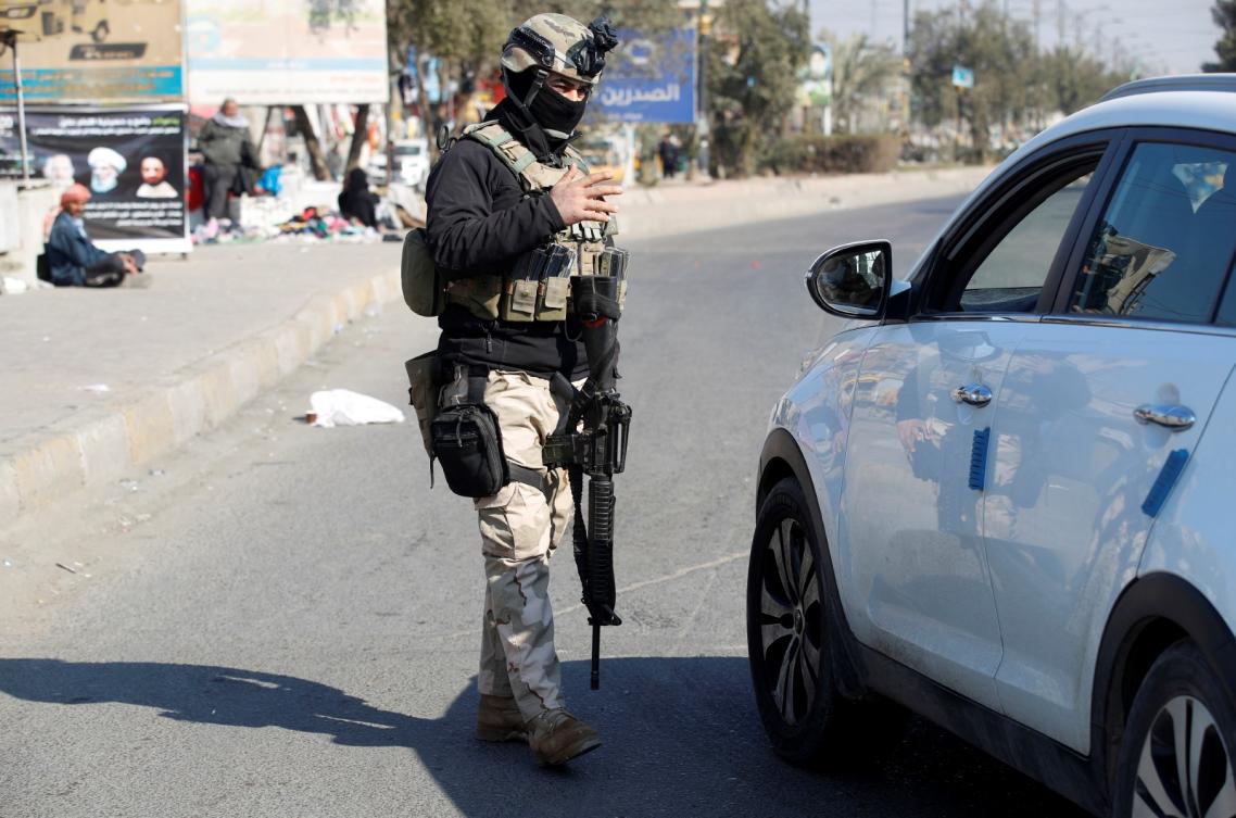 An Iraqi soldier manning a checkpoint in the capital Baghdad, checks a car on January 28, 2022. (AFP)